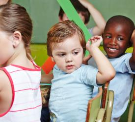 Three young children at school table.