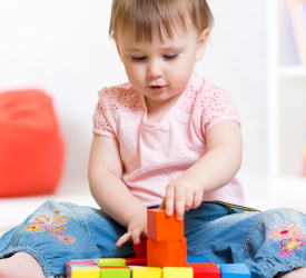 Cropped of toddler playing with blocks on the floor at home