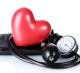 Blood pressure monitor set with a plastic red heart on top of the cuff