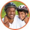 Head shot of two smiling adults wearing bicycle helmets.